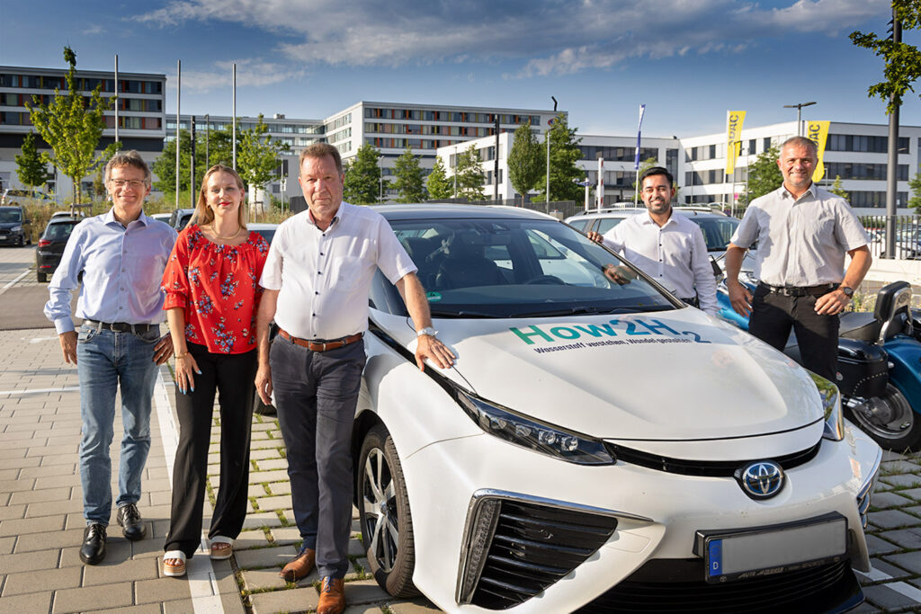 Vor das IHK-Haus der Wirtschaft in Villingen-Schwenningen fuhren die Consultants Kathrin Stangl und Maxim Dahawan (Zweiter von rechts) mit einem Wasserstoff-Auto vor. Ihr Unternehmen effisma aus Stuttgart berät im Zuge der Automotive-Transformation auch zu Themen der Wasserstoff-Nutzung, im Web zu finden unter www.how2-h2.de Außerdem im Bild von links: Erich Martin von Werma Signaltechnik sowie die Steinbeis-Berater Ulrich Schwellinger und Joachim Effinger. ©Foto:GerdLache